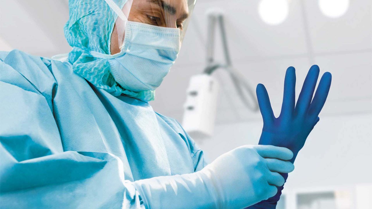 Chirurg, der Biogel Handschuhe mit Perforationsindikation verwendet