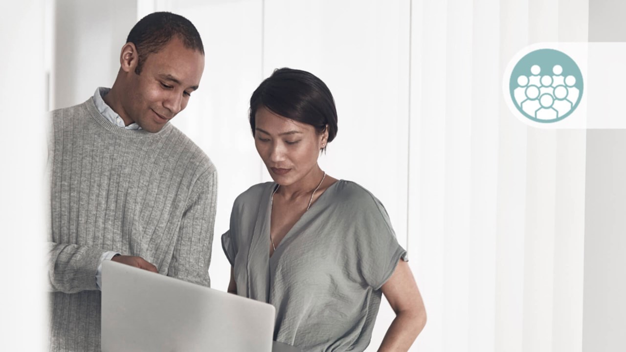 Een vrouw en een man discussiëren over een laptop